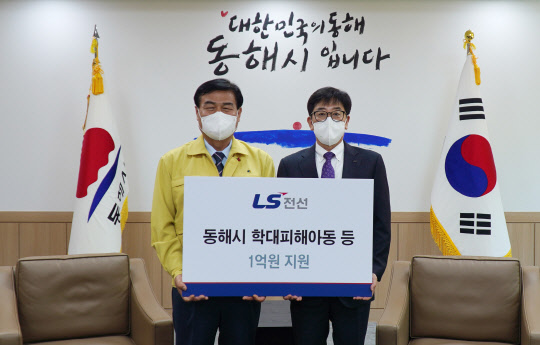 지난 20일 강원도 동해시청에서 김형원(오른쪽) LS전선 에너지사업본부장과 김규언 동해시장이 학대피해아동 등 취약계층에 1억원을 지원하는 전달식을 한 뒤 기념사진을 찍고 있다.           LS전선 제공